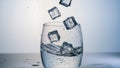Ice Cubes Falling Into a Glass Filled With Clear Water, Creating Splashes and Bubbles During a Sunny Day Royalty Free Stock Photo