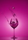 Ice cubes fall into a glass and water is poured out. Water splashing out of a tall wine glass. Royalty Free Stock Photo