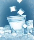 Ice cubes falling into glass of vodka on light blue background Royalty Free Stock Photo