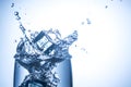 Ice cubes falling in glass with water splashes close up Royalty Free Stock Photo