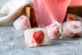 Ice cubes with frozen strawberries on table Royalty Free Stock Photo