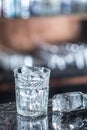 Ice cubes in glass at barcounter in night club or restaurant