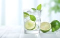 ice cubes, mint herb and fresh lime slices in glass on white wooden table