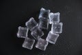 Ice cubes on a reflecting table with drops of water on a black background Royalty Free Stock Photo