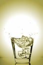 Ice cubes splashing into glass, ice cube dropped into glass of water Royalty Free Stock Photo