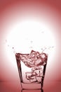 Ice cubes splashing into glass, ice cube dropped into glass of water Royalty Free Stock Photo