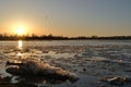 Ice drift on the river against the background of the golden sunset sky  reflected in the cold water. Spring landscape on the river Royalty Free Stock Photo