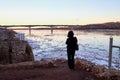 Ice drift on the river and girl watching it from high coast in the evening at sunset in the Northern part of Russia