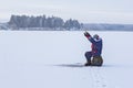 Ice fishing. Fisherman sitting on a frozen lake