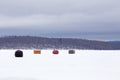 Ice fishing shelters on snow covered lake