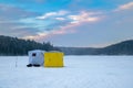 Ice fishing tent on a frozen lake at sunset. Fisherman camp on a peaceful winter evening Royalty Free Stock Photo