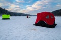 Ice fishing tent on a frozen lake at sunset. Fisherman camp on a peaceful winter evening Royalty Free Stock Photo