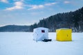 Ice fishing tent on a frozen lake at sunset. Fisherman camp on a peaceful winter evening Royalty Free Stock Photo