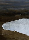 Ice floe at frozen lake surface with reflection