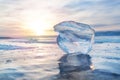 Ice floe at frozen surface with reflection and sunset. Baikal