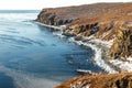 Ice floes floating in the winter sea off the snow-covered coast of Cape Tobizin on the Russian island