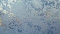 Ice and frost on the window pane in winter. A pattern of frozen water crystals, similar to the leaves of fantastic plants or Royalty Free Stock Photo