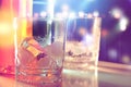 Ice in glass in nightlife with blurred background. Royalty Free Stock Photo