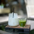 Ice green tea cup and glass jars of milk on the wooden table in the cafe background with copy space Royalty Free Stock Photo