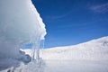 Ice grotto, or cave with icicles, blue landscape and blue sky on Baikal