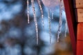 Ice hems on a roof in cold winter melting on sunny day Royalty Free Stock Photo