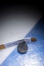 An ice hockey puck and stick at the blue line Royalty Free Stock Photo