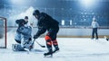 Ice Hockey Rink Arena: Goalie Against Forward Player who is Doing Slapshot, Shots Puck with Stick Royalty Free Stock Photo