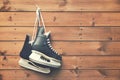 ice hockey skates hanging on nail on wooden background Royalty Free Stock Photo