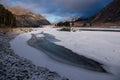 Ice-hole in ice-covered river on the background of a colorful sunrise and high rocks, Altai mountains Royalty Free Stock Photo