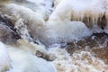 Ice and icicles by the flowing water in the creek Royalty Free Stock Photo