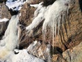 Ice icicles hanging from rocks, sunny day in Norway