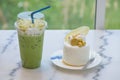 Ice matcha green tea in plastic cup and Coconut cake decorated with golden leaf, biscuits and white chocolate Royalty Free Stock Photo