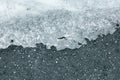 Ice melting on pavement or black asphalt road in spring Royalty Free Stock Photo