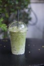 Ice milk green tea in plastic glass on table in coffee shop Royalty Free Stock Photo