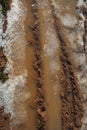 Ice on mud red clay soil road with tyres lines