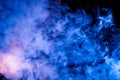 Ice pattern of a rising pair of blue exhaled vape neon blue on a black background with curly streams of smoke