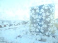 Ice patterns on the window. Beautiful curls and crystals on glass. Outside the window there is a blue winter sky, snow and a city