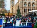 London, UK/Europe; 21/12/2019: Ice rink and Christmas tree at Natural History Museum in London. People enjoying ice skating at