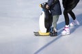 Ice rink. Mom teaches a child to skate. A boy holds a penguin for support. Winter family activities and sport concept Royalty Free Stock Photo