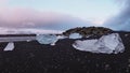 Ice rocks and black rocks over black sand beach at Diamond beach Iceland