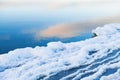 Ice on the shore of lake. Sky with clouds reflected in the cold water at sunset Royalty Free Stock Photo