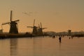 Ice skater on a frozen windmill canal at sunrise moment