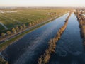 Ice skating in nature, dutch Winter Enchantment: Aerial View of Ice Skaters on Frozen Canals. Birds eye aerial drone