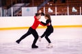 Boy and girl are engaged in figure skating in the ice arena