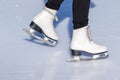 Ice skating, woman legs wearing white leather skates, training on a frosen snowy skating rink in winter close up Royalty Free Stock Photo