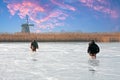 Ice sledging on a cold winterday at the windmill in the Netherlands at sunset Royalty Free Stock Photo