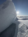 Ice slopes in sunny winter day, transparent ice of blue color, purely blue sky, long shadows, a pure snow-covered virgin