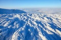 On ice and snow covered mountain top opens a beautiful view of the boundless blue sky, dense textured fog in winter day. Royalty Free Stock Photo