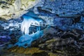 Ice stalagmites in blue light fantastic in a beautiful cave with numerous mining deposits Royalty Free Stock Photo