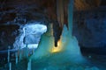 Ice stalagmites and stalactites illuminated by candles and fluorescent light inside the marble mine